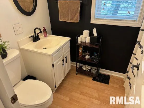 a bathroom with a sink mirror vanity and toilet