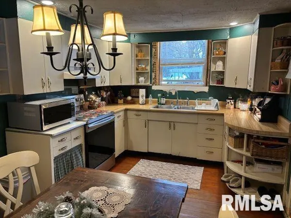 a kitchen with a stove cabinets and wooden floor