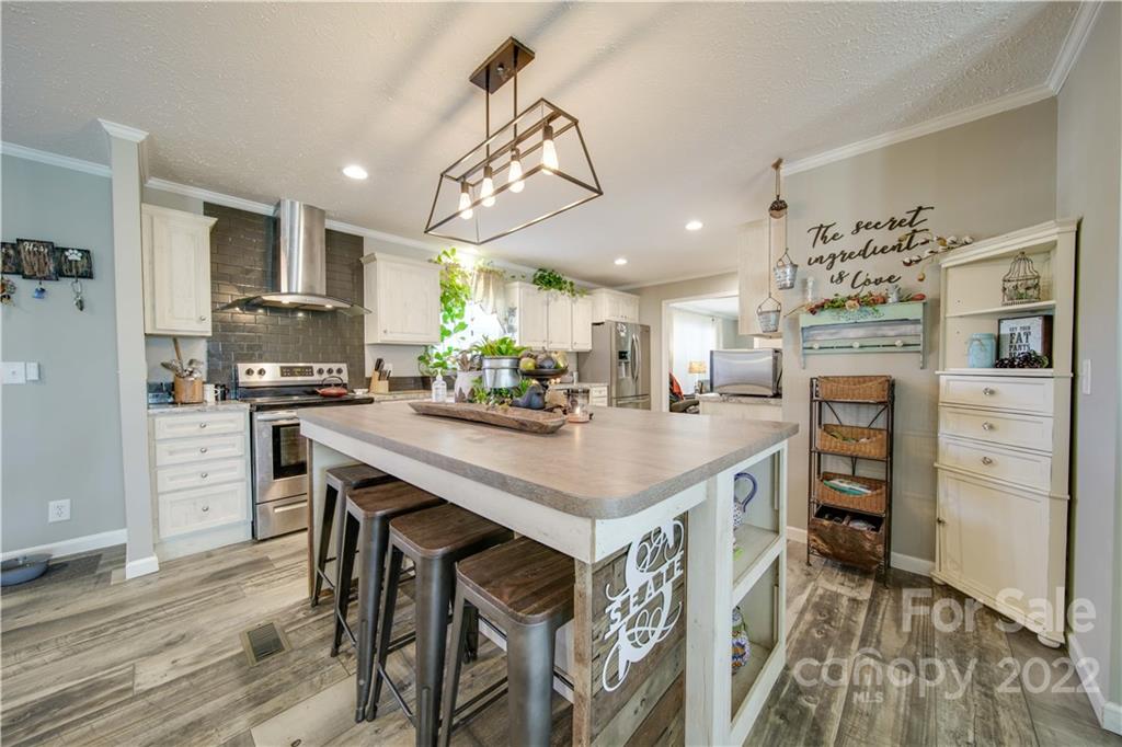 1540 Campbell Road Jefferson, SC 29718 - Photo 7 of 40 a kitchen with stainless steel appliances kitchen island granite countertop a table chairs in it and wooden floors