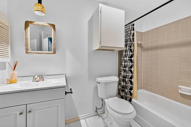 a white toilet sitting next to a bathroom sink and a shower