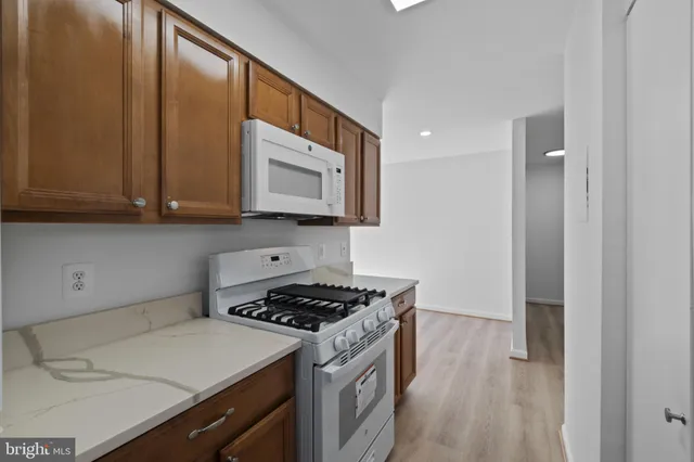 a kitchen with stainless steel appliances a stove microwave and sink