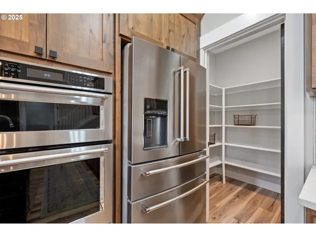 a metallic refrigerator freezer sitting inside of a kitchen