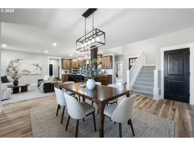 a dining room with wooden floor a chandelier a wooden table and chairs