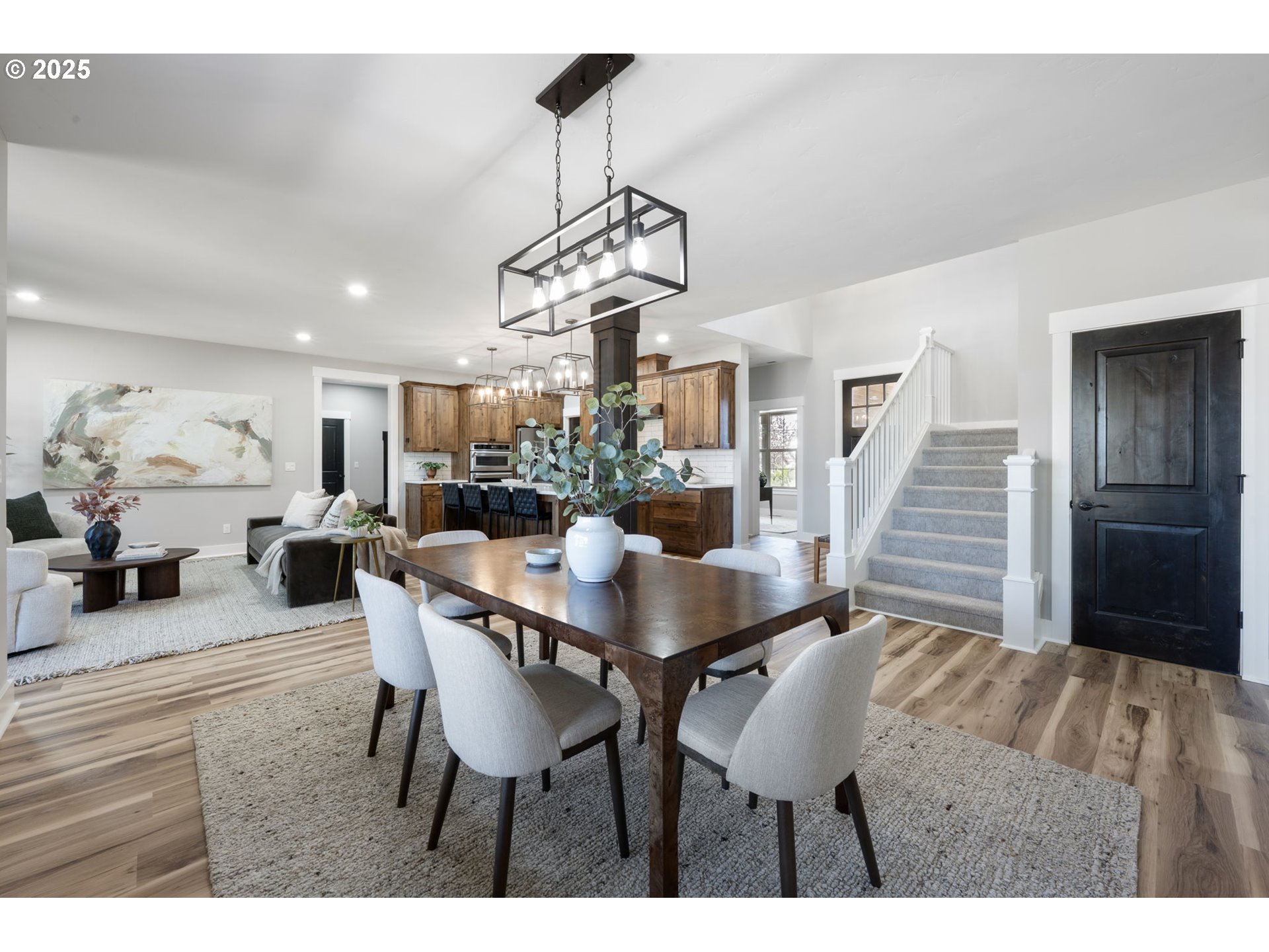 16486 Southwest Ranchview Road Powell Butte, OR 97753 - Photo 16 of 44 a dining room with wooden floor a chandelier a wooden table and chairs