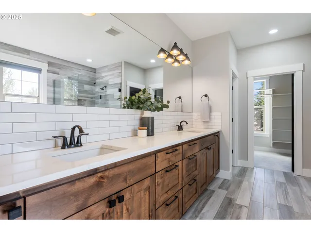 a bathroom with a double vanity sink a mirror and a shower