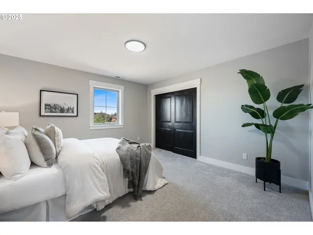 a bed room with a bed and painting on the wall