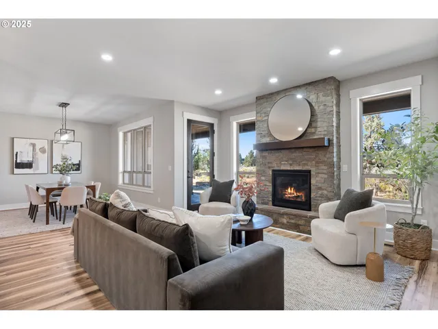 a living room with furniture fireplace and a large window