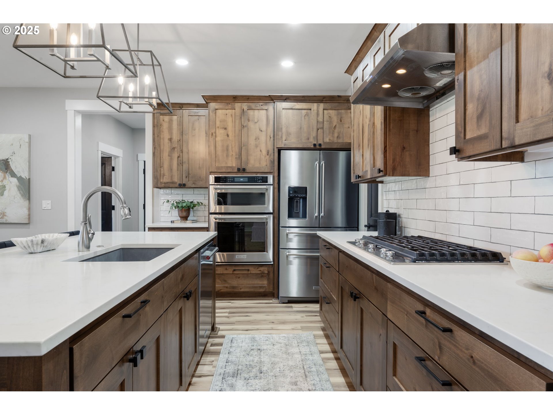 16486 Southwest Ranchview Road Powell Butte, OR 97753 - Photo 10 of 44 a kitchen with a sink a refrigerator and a stove top oven with wooden floor