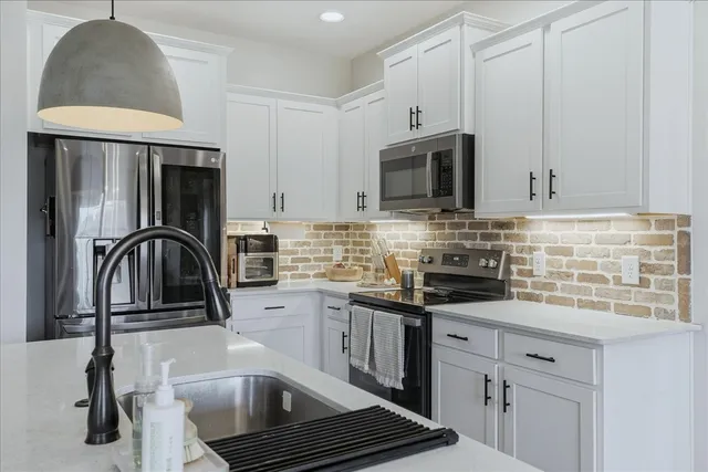 a kitchen with stainless steel appliances a stove a sink a microwave and cabinets