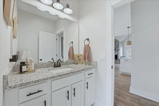 a bathroom with a granite countertop sink and a mirror