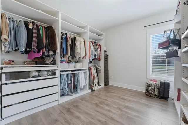 a view of walk in closet with clothes and shoes