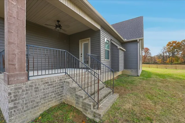 a front view of a house with a yard and trees