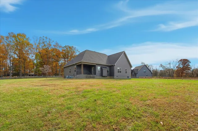 a view of a house with a yard and a large tree
