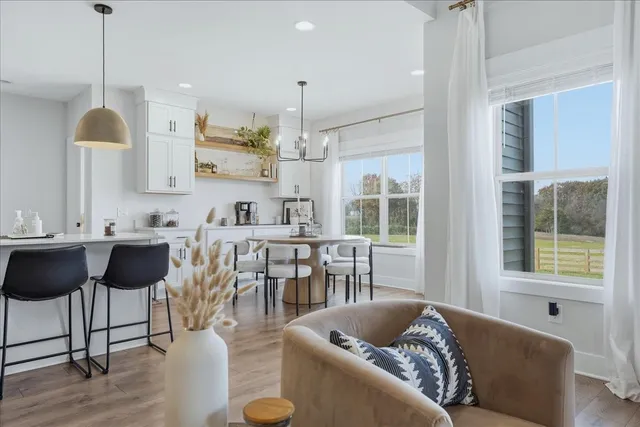 a living room with furniture a dining table and a large window