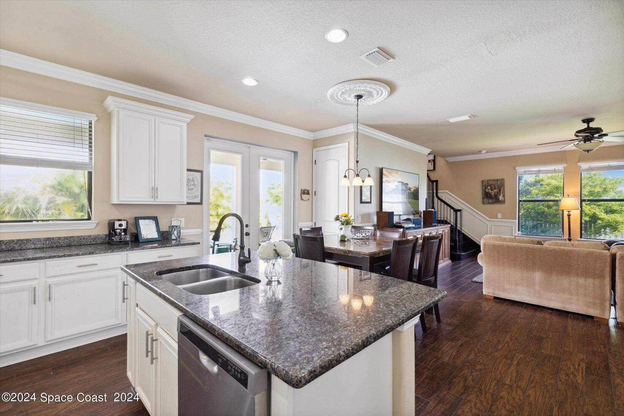 110 Poinsetta Street Indialantic, FL 32903 - Photo 17 of 67 a kitchen with granite countertop a sink a counter top space and living room view