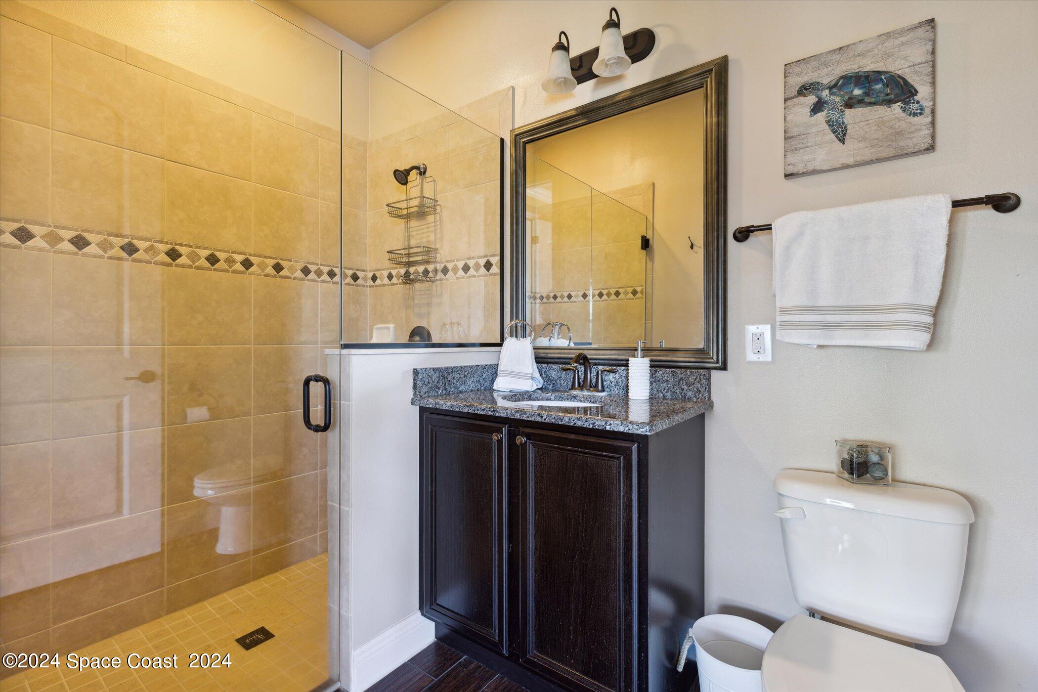 110 Poinsetta Street Indialantic, FL 32903 - Photo 28 of 67 a bathroom with a granite countertop sink a toilet and shower