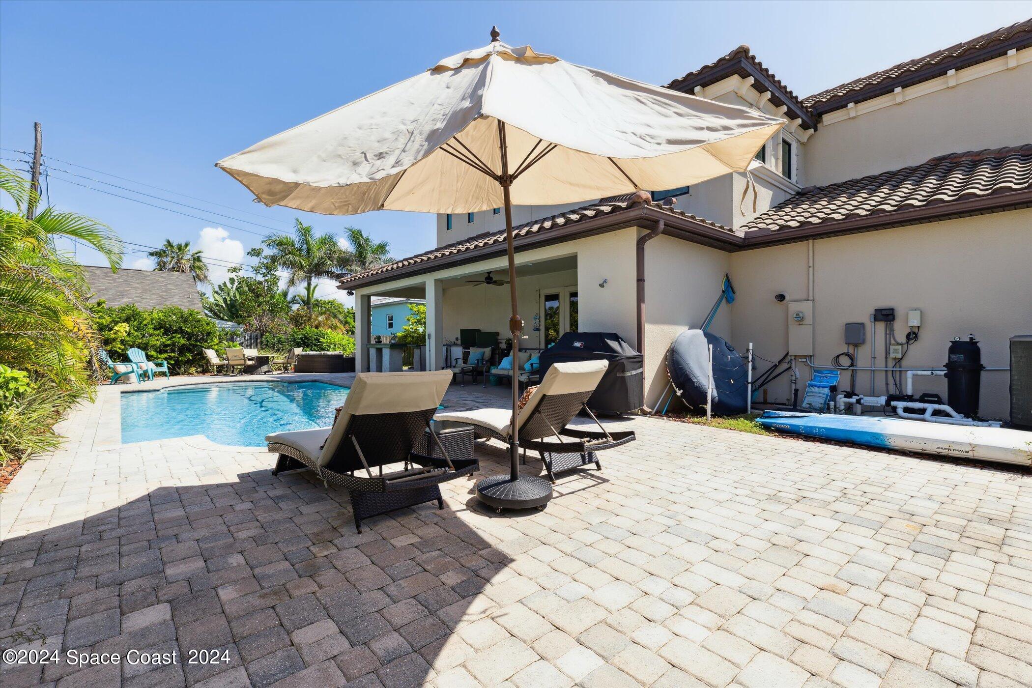 110 Poinsetta Street Indialantic, FL 32903 - Photo 65 of 67 a view of a patio with a table and chairs under an umbrella