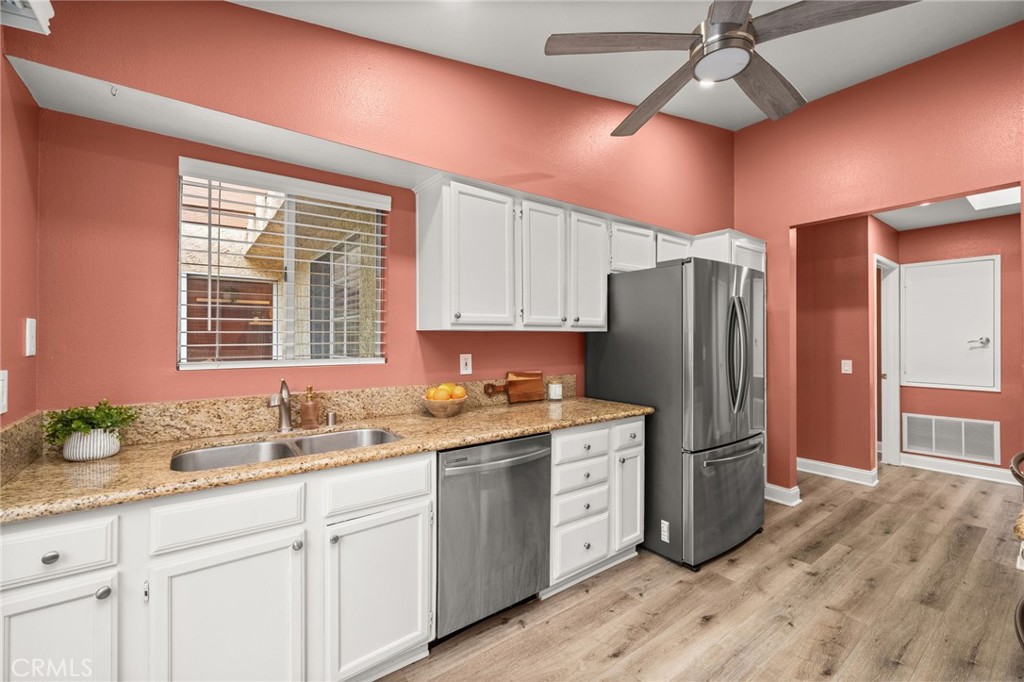 5470 Copper Canyon Road, Unit 2E Yorba Linda, CA 92887 - Photo 3 of 25 a kitchen with a refrigerator a sink and dishwasher with wooden floor