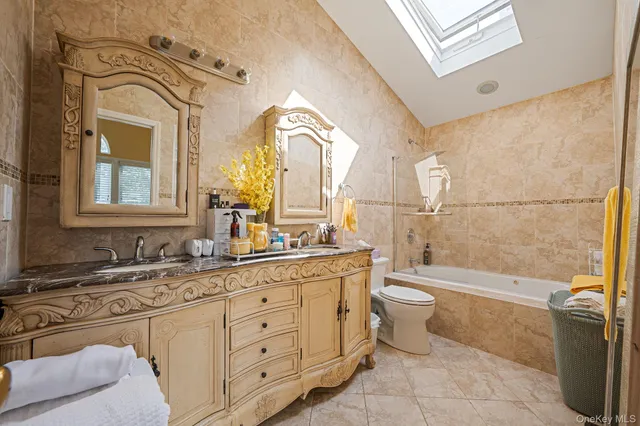 a spacious bathroom with a double vanity sink a mirror and a bathtub