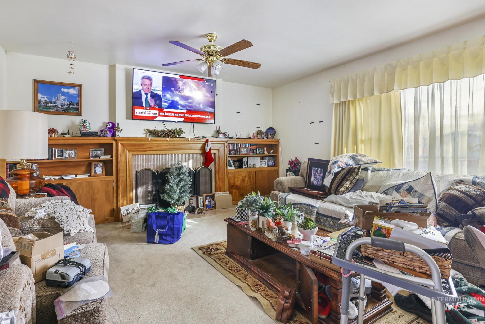 818 Union Avenue Filer, ID 83328 - Photo 7 of 20 Carpeted living area with a fireplace with raised hearth and ceiling fan