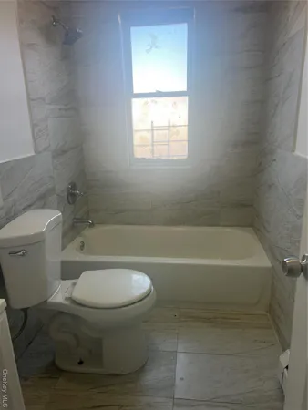 a bathroom with a toilet and a bath tub