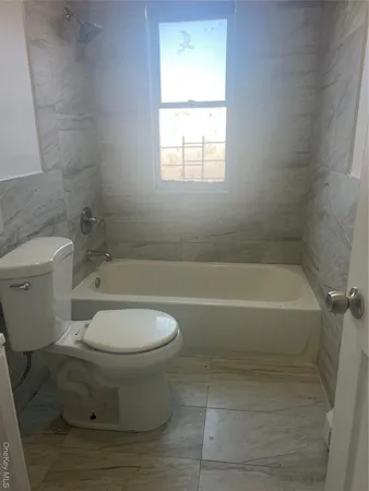 a bathroom with a toilet and a bath tub