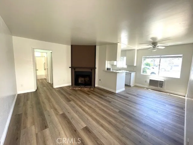 a room with stainless steel appliances a kitchen island hardwood floor and a window