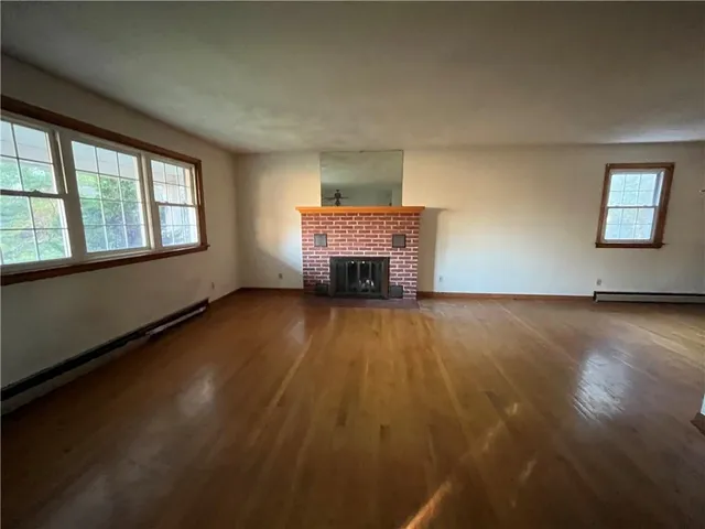 an empty room with windows fireplace and windows