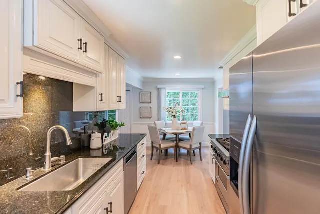 a kitchen with granite countertop a sink appliances and cabinets