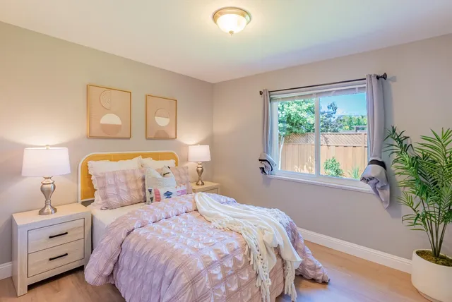 a bedroom with a bed and a potted plant