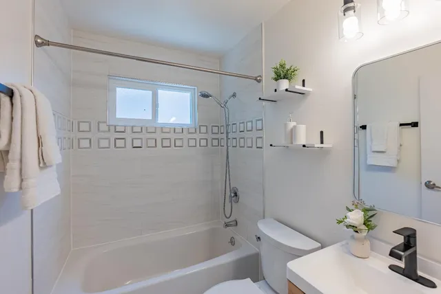 a bath room with a bathtub shower and a sink