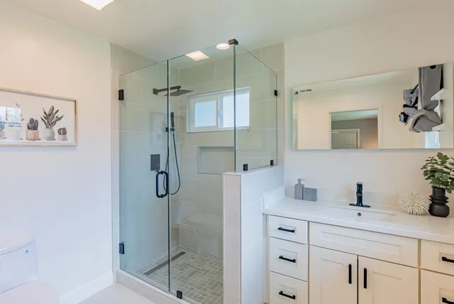 a bathroom with a shower sink and mirror
