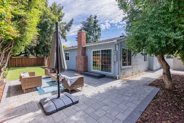 a view of a backyard with furniture and a tree