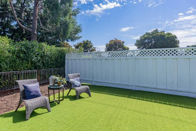 a view of a chair and table in the backyard