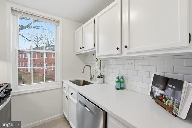 a kitchen with white cabinets and a sink