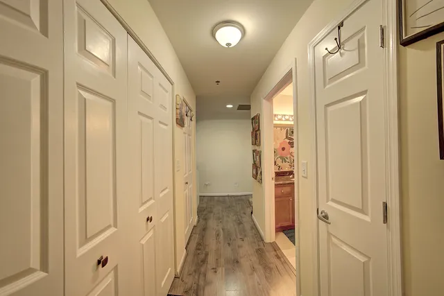 a view of a hallway with wooden floor and staircase
