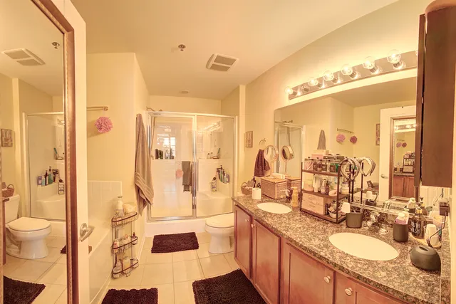 a bathroom with a double vanity sink toilet mirror and shower