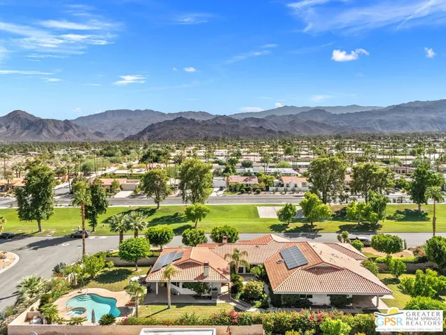 an aerial view of residential houses with outdoor space and swimming pool
