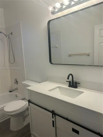 a bathroom with a sink a toilet and mirror