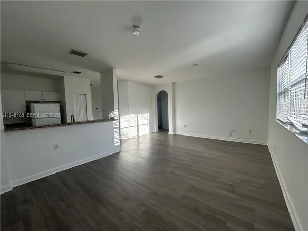 a view of a livingroom with wooden floor and a window