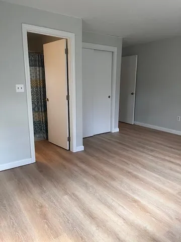 an empty room with wooden floor and closet