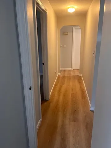a view of a hallway with wooden floor