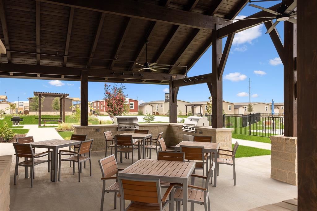 153 Cabrera Street Oak Point, TX 75068 - Photo 18 of 22 Outdoor covered community patio featuring a wood-beam ceiling with an integrated ceiling fan and outdoor grills