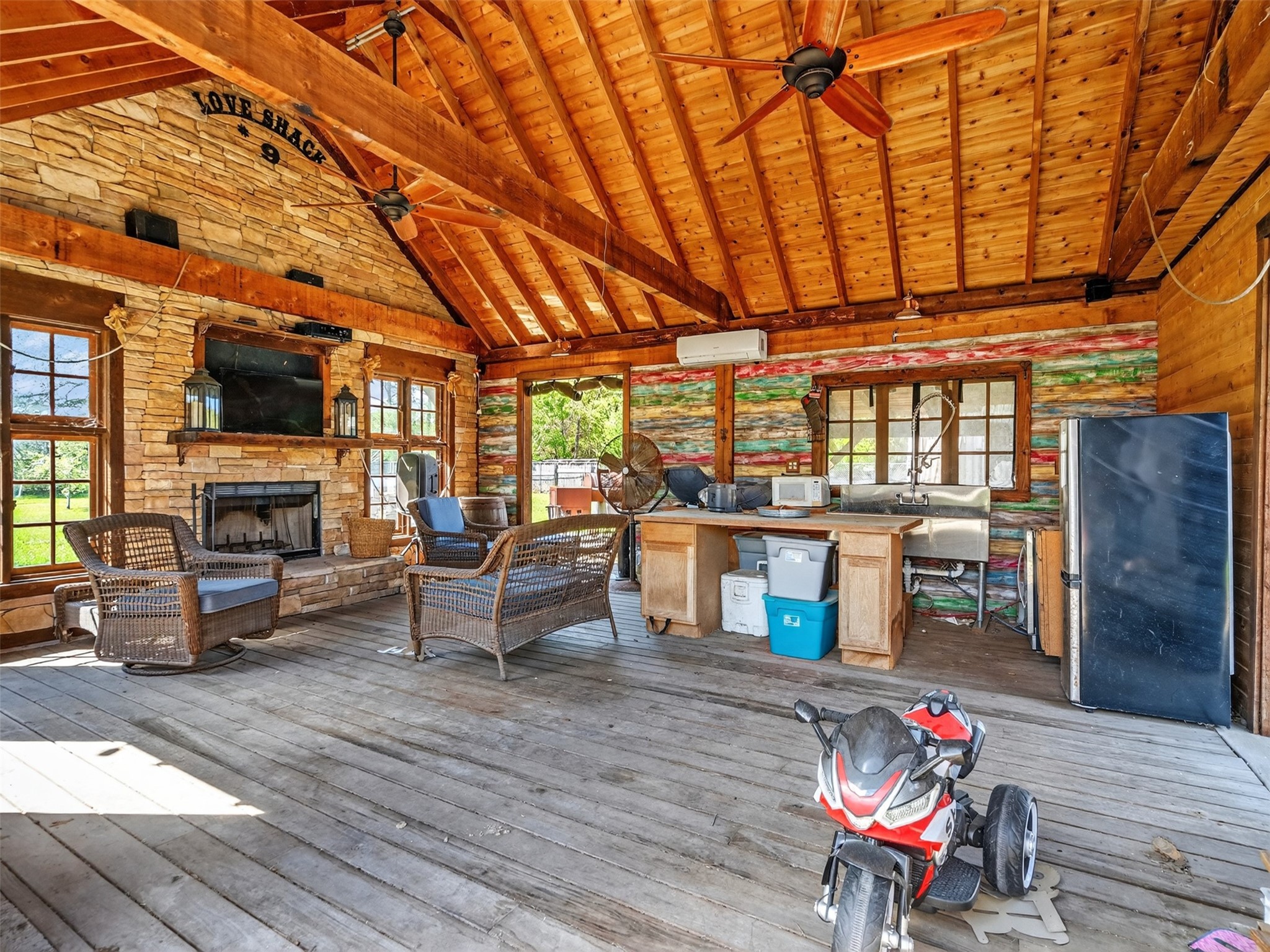 5036 Singletary Road Alvin, TX 77511 - Photo 27 of 35 Spacious outdoor living area featuring wood-beam ceilings, fireplace, and full entertaining setup.