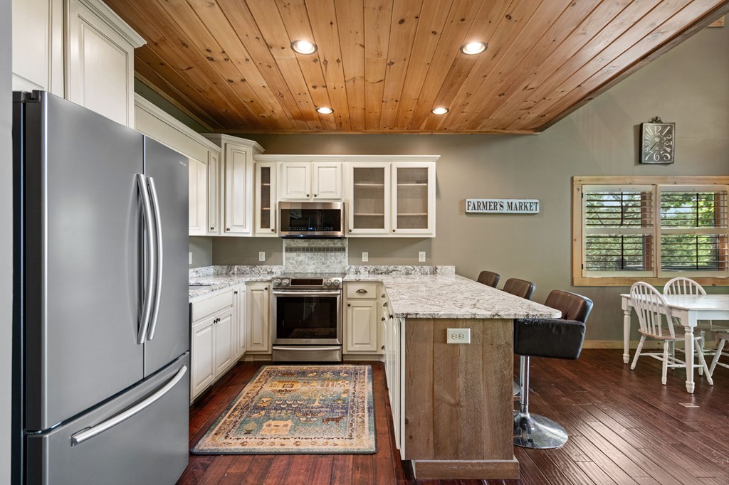 479 Big Timber Road Mineral Bluff, GA 30559 - Photo 12 of 60 a kitchen with stainless steel appliances granite countertop a stove refrigerator and microwave