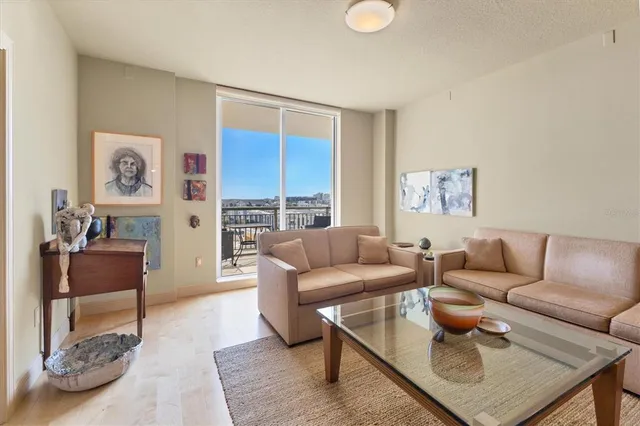 a dining hall with stainless steel appliances a dining table wooden floor and a kitchen view