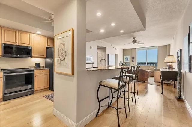 a large kitchen with stainless steel appliances kitchen island granite countertop a refrigerator and a stove top oven