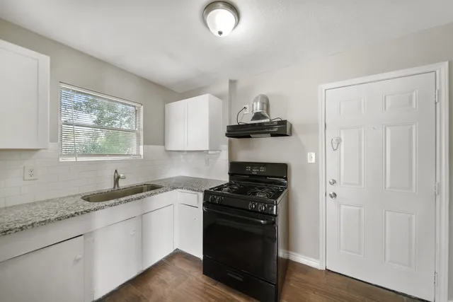 a kitchen with stainless steel appliances a sink stove and cabinets