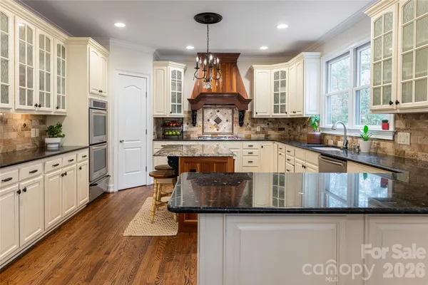 a large kitchen with stainless steel appliances granite countertop a stove and a refrigerator