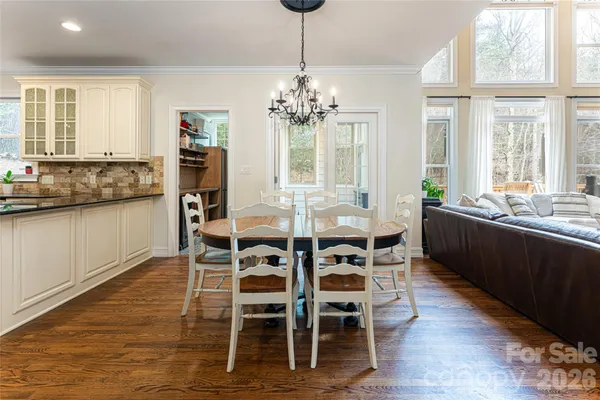 a dining room with furniture a chandelier and wooden floor